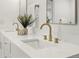 Modern bathroom with dual sinks, white countertops, and gold fixtures, offering a clean and stylish design at 7382 W Stanford Ave, Littleton, CO 80123