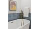 Close-up of a soaking tub with gold fixtures and blue accent tiles at 7382 W Stanford Ave, Littleton, CO 80123