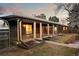View of the home's exterior showcasing a covered patio, sunroom, and well-manicured landscaping at 7382 W Stanford Ave, Littleton, CO 80123