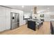 Bright kitchen with a large island, breakfast bar, and stainless steel refrigerator at 7382 W Stanford Ave, Littleton, CO 80123