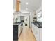Modern kitchen with stainless steel appliances, large island, and view to fireplace at 7382 W Stanford Ave, Littleton, CO 80123