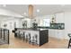 Modern kitchen boasts a spacious island, stainless steel appliances, and sleek white cabinetry at 7382 W Stanford Ave, Littleton, CO 80123