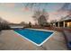 Large in-ground pool surrounded by a patio and privacy wall for outdoor enjoyment at 7382 W Stanford Ave, Littleton, CO 80123