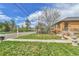 Well-maintained front yard with healthy green grass, landscaping, and a sidewalk leading to the home at 1658 Winona Ct, Denver, CO 80204