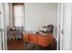 Bright home office featuring a wooden desk, globe, and large window with wood blinds at 2320 N Lafayette St, Denver, CO 80205