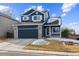 Stunning two-story home, navy blue exterior, two-car garage, and nicely landscaped yard at 9790 Moss Rose Cir, Highlands Ranch, CO 80129