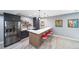 Basement bar with custom cabinetry, stainless steel refrigerator, and seating for three at 2732 S Jackson St, Denver, CO 80210