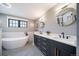 Spa-like bathroom with freestanding tub, dual vanity, and designer tile flooring at 2732 S Jackson St, Denver, CO 80210