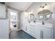 Bright bathroom features a double vanity, sleek mirrors, and a glimpse into the connected bedroom at 2732 S Jackson St, Denver, CO 80210