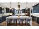 Modern kitchen with white countertops, black cabinetry, stainless appliances, and pendant lighting over a large island at 2732 S Jackson St, Denver, CO 80210