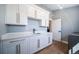 Well-equipped laundry room with white cabinetry, quartz countertop, and hardwood floors at 2732 S Jackson St, Denver, CO 80210