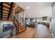 Open-concept living room with hardwood floors, modern staircase, and a cozy seating area with natural light at 2732 S Jackson St, Denver, CO 80210