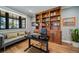 Stylish home office featuring a modern desk, built-in wooden shelving, and a comfortable seating area with natural light at 2732 S Jackson St, Denver, CO 80210