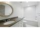 Elegant bathroom featuring a large vanity and a shower-over-tub with subway tile at 1050 S Gilpin St, Denver, CO 80209