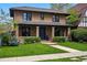 Charming brick two-story home with covered front porch and manicured lawn at 1050 S Gilpin St, Denver, CO 80209