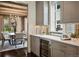Charming kitchen with grey cabinetry, a wine fridge, marble countertops, and a view of the dining room at 1050 S Gilpin St, Denver, CO 80209