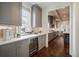Elegant kitchen with grey cabinets, marble countertops, and dark hardwood floors, with a wine fridge at 1050 S Gilpin St, Denver, CO 80209