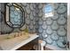 Stylish powder room featuring bold wallpaper, marble countertop, and elegant fixtures at 1050 S Gilpin St, Denver, CO 80209
