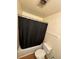 Simple bathroom with a tub, shower, toilet, and a black shower curtain at 2241 Dexter Dr # 2, Longmont, CO 80501