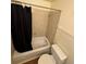 Clean bathroom featuring a shower/tub with a shower curtain, toilet, and neutral tile surround at 2241 Dexter Dr # 2, Longmont, CO 80501