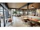 Stylish restaurant interior with wood tables, booth seating, and large windows with greenery at 1643 Boulder St # 211, Denver, CO 80211