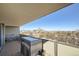 Outdoor balcony seating area with a wicker table and stools overlooking a panoramic cityscape and mountain view at 1085 N Lafayette St # 804, Denver, CO 80218
