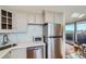 Updated kitchen with stainless steel appliances, white cabinets, stone countertops, and a view to the balcony at 1085 N Lafayette St # 804, Denver, CO 80218