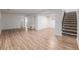 Open basement layout with wood-look floors, white walls and a staircase with neutral carpet at 2452 S Norfolk St, Aurora, CO 80013
