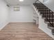 Finished basement area with wood-look floors and stairs leading to the upper level at 2452 S Norfolk St, Aurora, CO 80013