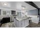Bright kitchen featuring stainless appliances, light gray backsplash, island with barstool seating, and sliding doors to backyard at 2452 S Norfolk St, Aurora, CO 80013