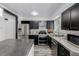 Kitchen area showcasing stainless steel appliances, a large kitchen island, and dark cabinetry and light countertops at 2452 S Norfolk St, Aurora, CO 80013