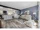 Bright open living room with hardwood floors, modern furniture, and an open concept kitchen and dining area at 2452 S Norfolk St, Aurora, CO 80013