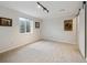 A carpeted basement space with track lighting, a window, and ready for personalization at 17794 E Bellewood Dr, Aurora, CO 80015