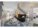 Living room featuring a stone fireplace, staircase, and view to the dining area at 17794 E Bellewood Dr, Aurora, CO 80015