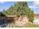 Fenced backyard showcases a serene stone fountain area surrounded by mature trees and garden beds at 9294 Melborne Ct, Parker, CO 80134