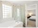 Well-lit bathroom showcasing a glass-enclosed shower and soaking tub next to the bedroom at 9294 Melborne Ct, Parker, CO 80134