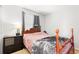 Cozy bedroom featuring a wood frame bed, bedside table, and natural light from the window at 9294 Melborne Ct, Parker, CO 80134