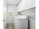 Well-lit laundry room with side by side machines and white cabinets at 9294 Melborne Ct, Parker, CO 80134
