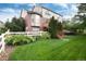 Spacious backyard with a white fence, lush greenery, and access stairs to the upper deck at 2959 W 110Th Pl, Westminster, CO 80234