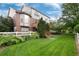 Expansive backyard features a manicured lawn, white fence, mature trees, and a staircase leading to the deck at 2959 W 110Th Pl, Westminster, CO 80234