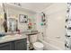 Bright bathroom with a tub, shower and gray cabinets and Hollywood artwork at 6280 Snowberry Ave, Firestone, CO 80504
