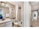 Well-lit bathroom featuring a vanity with a sink, a toilet, and a shower with a white curtain at 17153 W 91St Ln, Arvada, CO 80007