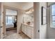 Bathroom showcasing a double sink vanity with decorative accessories and framed art, leading into the main bedroom at 17153 W 91St Ln, Arvada, CO 80007