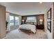 Beautiful main bedroom featuring a large bed with decorative pillows, a bench, bedside tables, and wall art at 17153 W 91St Ln, Arvada, CO 80007