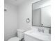 Well-lit half bathroom features modern fixtures, white vanity, and a sleek, black-framed mirror at 15045 E Louisiana Dr # B, Aurora, CO 80012