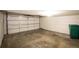 An empty garage shows the interior with a closed garage door and a green recycling bin at 15045 E Louisiana Dr # B, Aurora, CO 80012