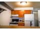 Small kitchen with white appliances and wood cabinets at 1196 N Grant St # 113, Denver, CO 80203