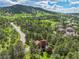 Aerial view showcases the property's serene setting among trees and lush landscaping at 23485 Bluestem Dr, Golden, CO 80401