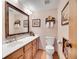Traditional bathroom with wood cabinets, vanity, mirror, framed art, and toilet at 23485 Bluestem Dr, Golden, CO 80401