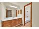 Bathroom with wood cabinets, updated vanity and framed mirror, and shower-tub combo at 23485 Bluestem Dr, Golden, CO 80401